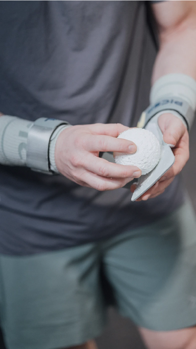 Persona aplicando magnesio en polvo con una bola sobre unas calleras de crosstraining